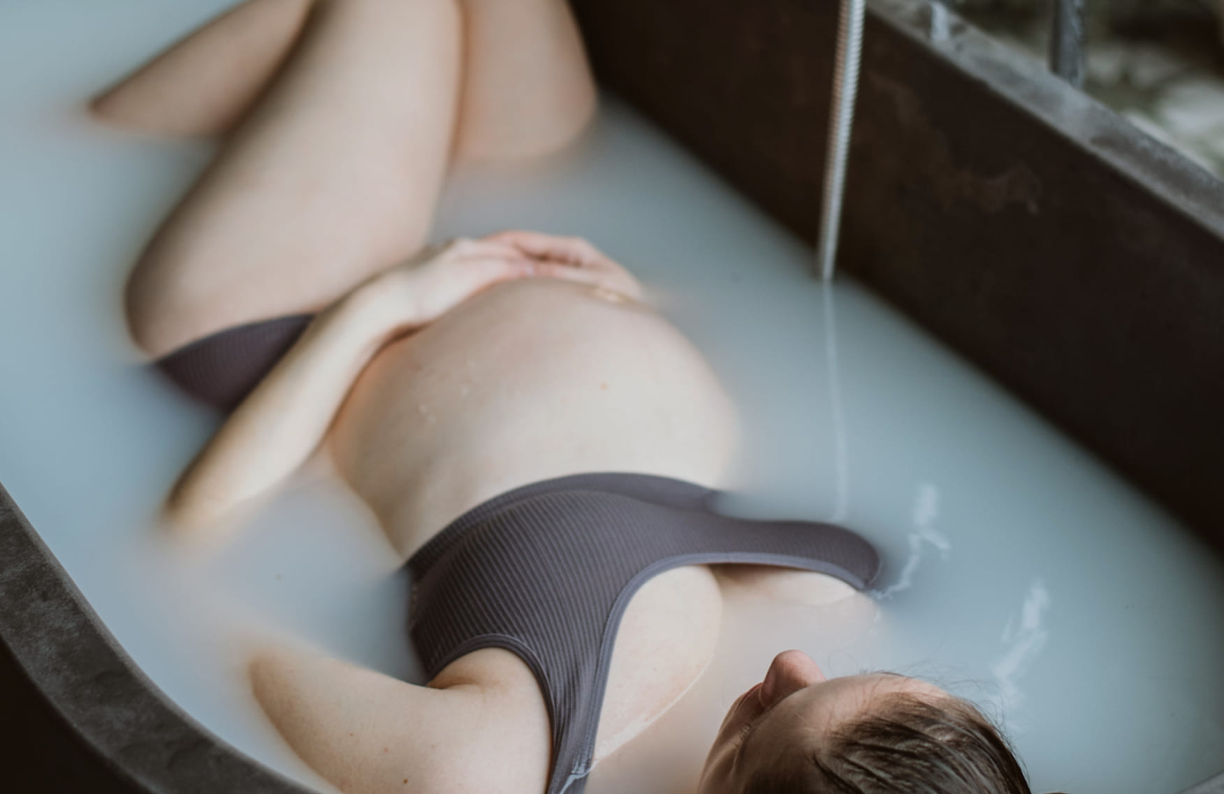 Pregnant woman lying in a milky bath