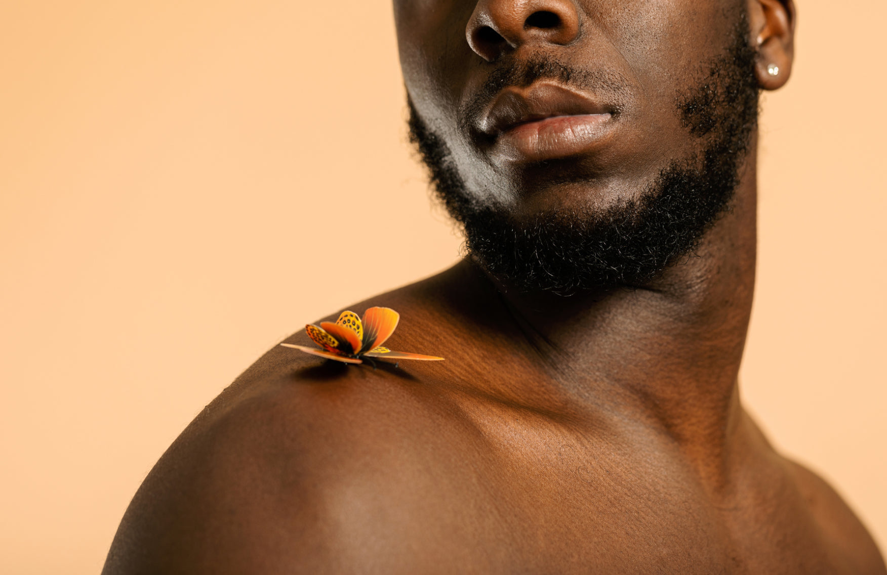 Man looking at a butterfly that has landed on his shoulder