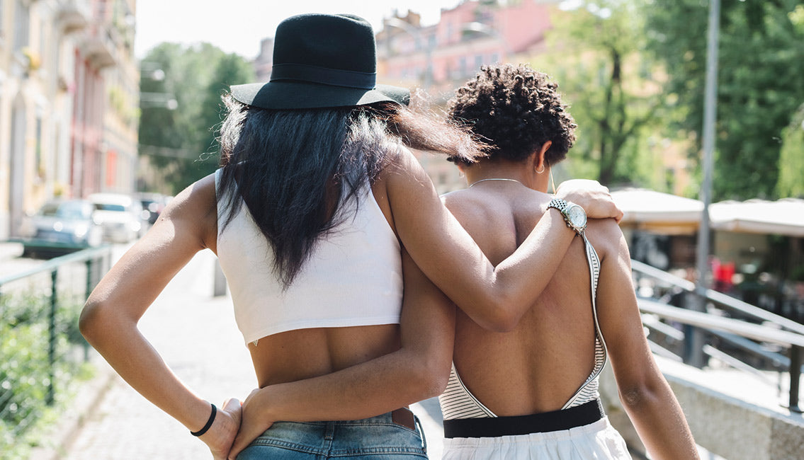 Two woman walking with arms around each other
