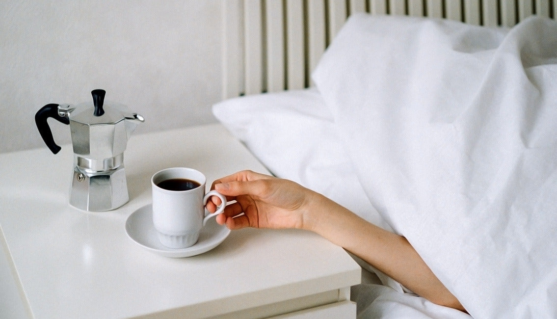 Person in bed drinking coffee