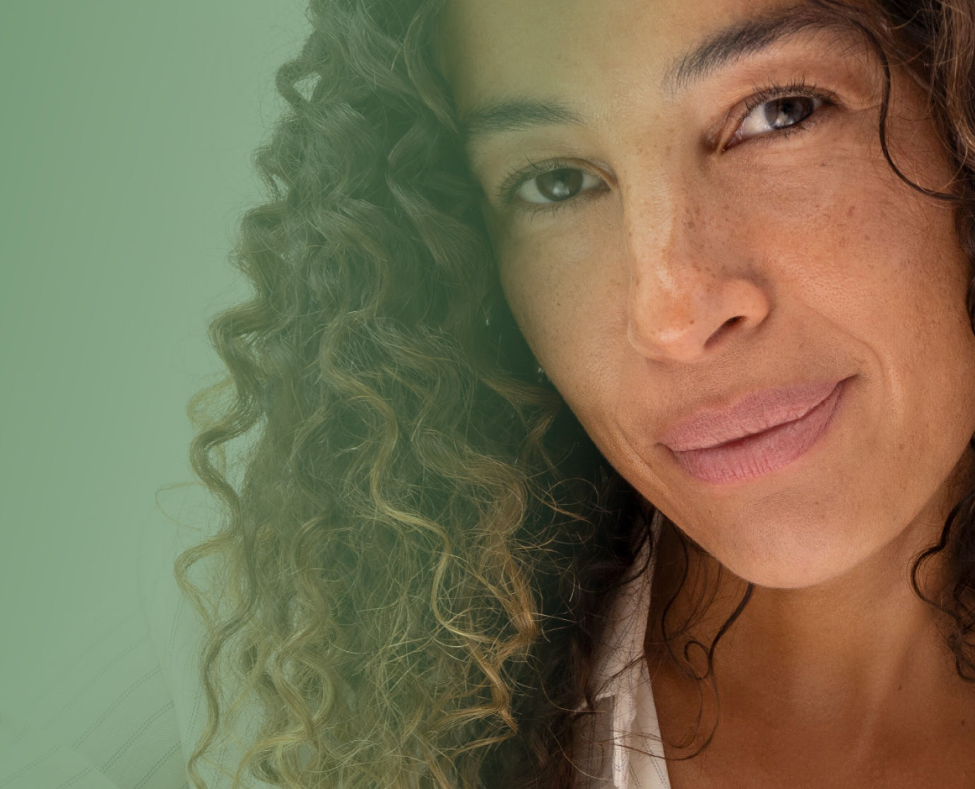 Close-up of a woman with curly hair against a green background