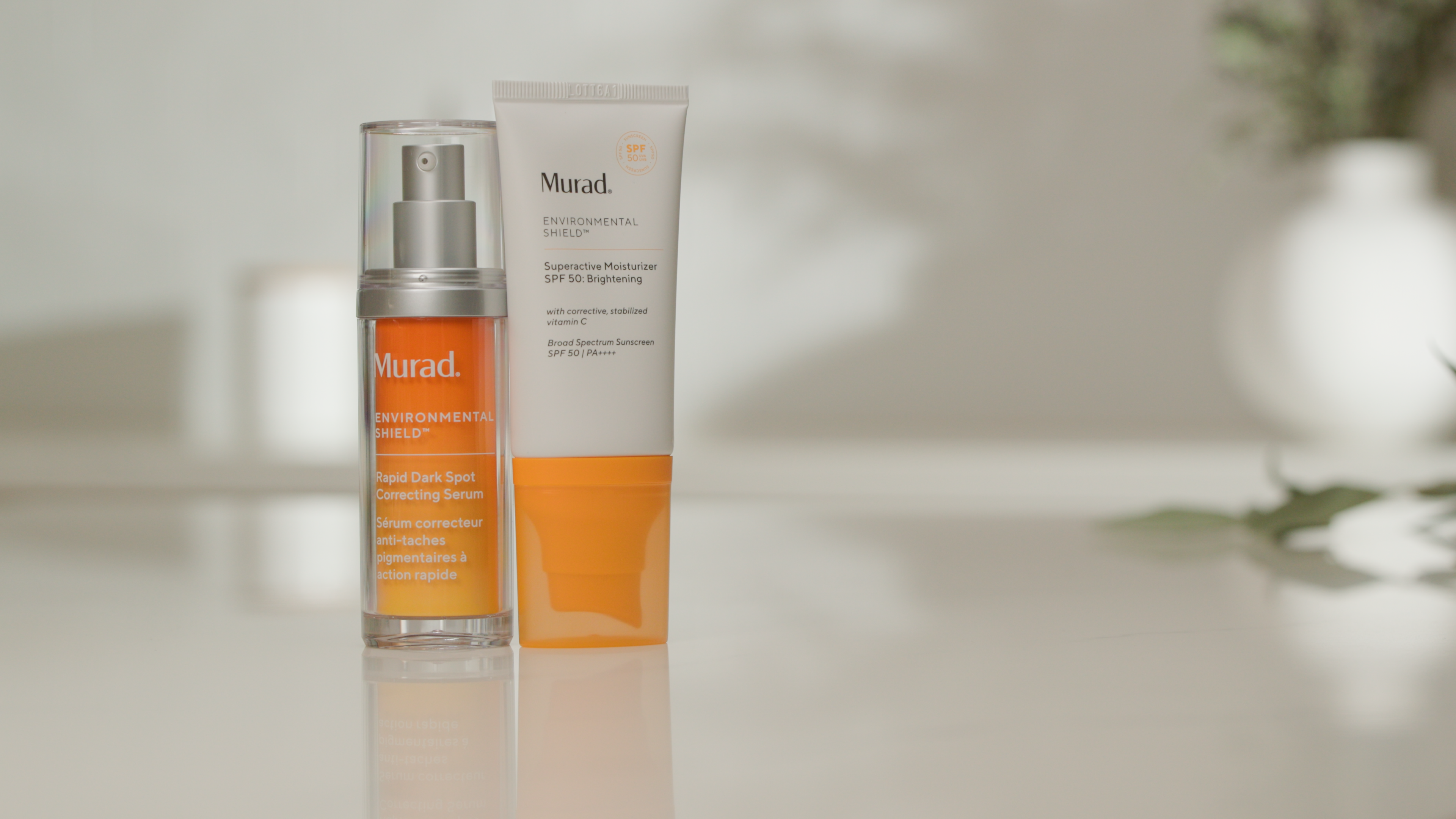 Two bottles of Murad skincare products on a neutral background